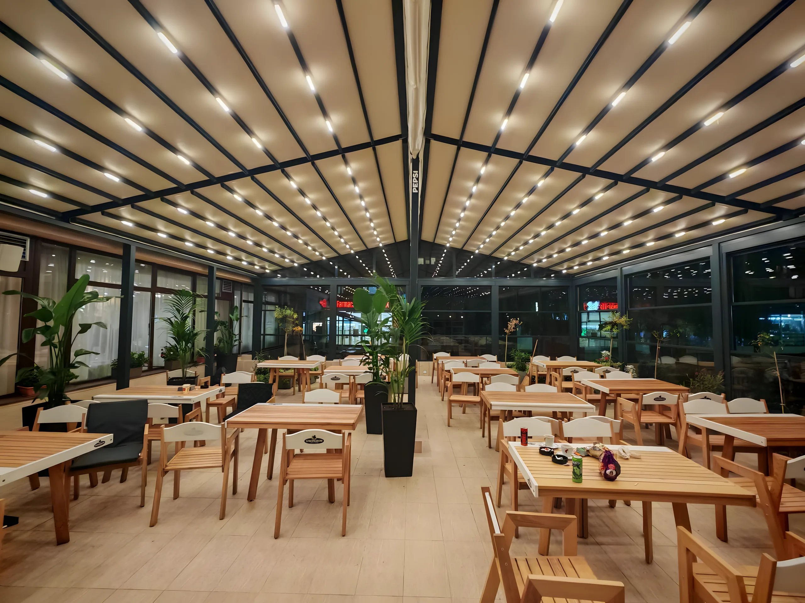 Terasă de restaurant închisă, cu acoperiș retractabil textil pe structură de aluminiu antracit