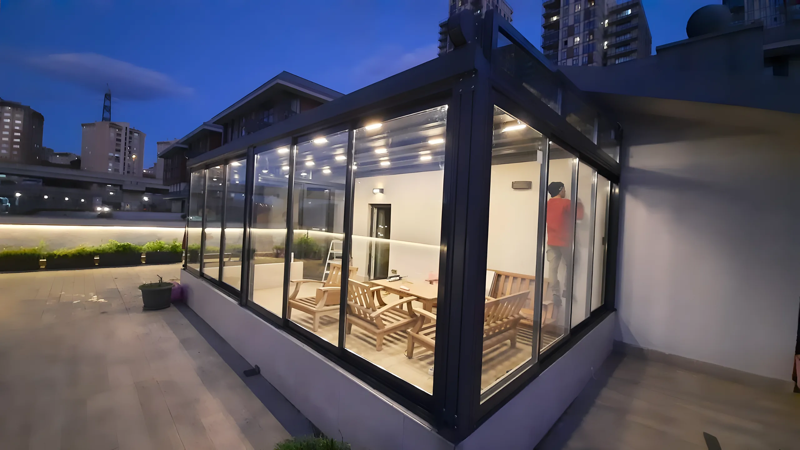 Grădină de iarnă din sticlă și aluminiu antracit, iluminată cu LED, pe terasa unui apartament