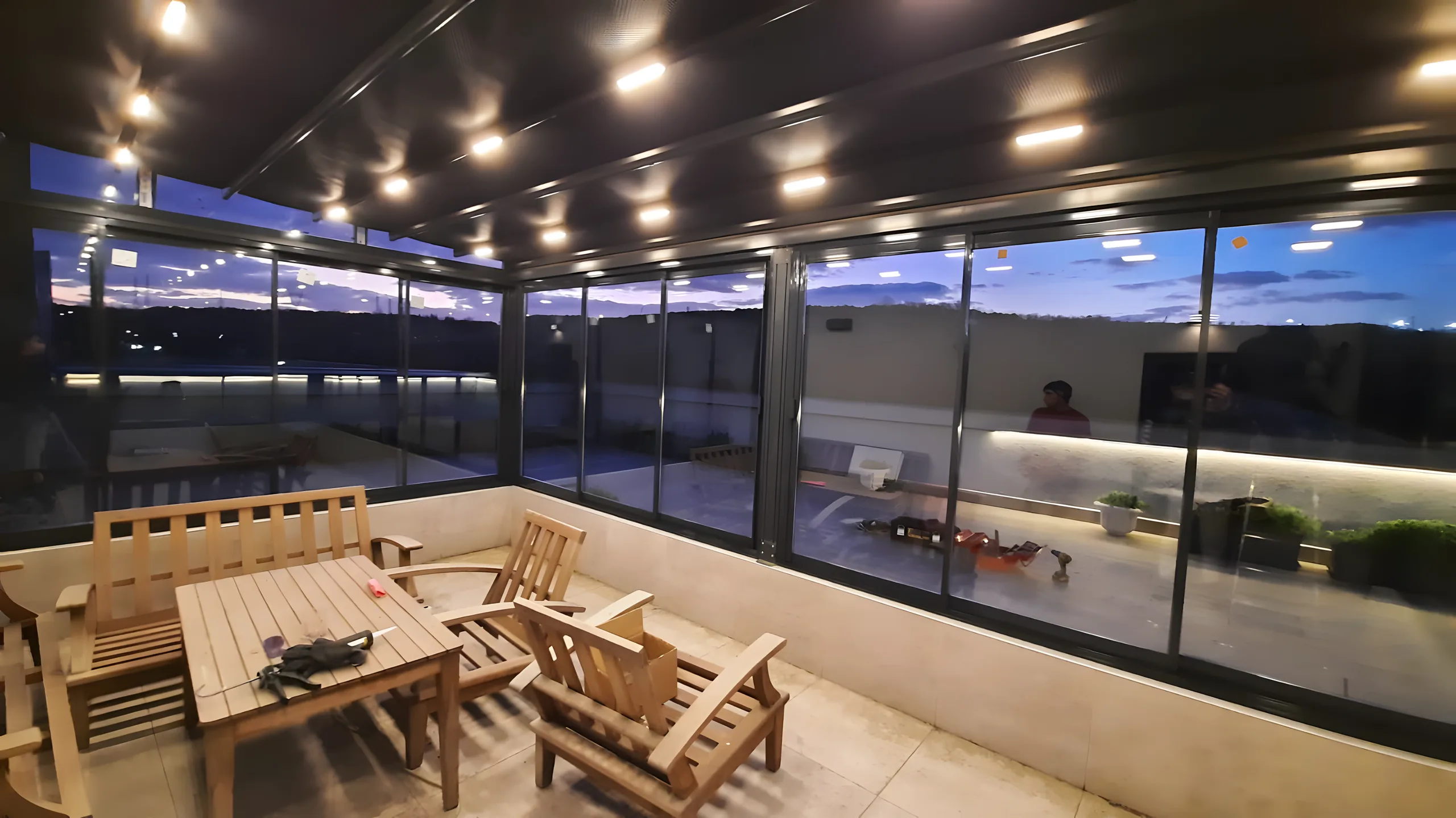 Vedere panoramică din interiorul unei grădini de iarnă vitrate, cu tavan de aluminiu cu spoturi