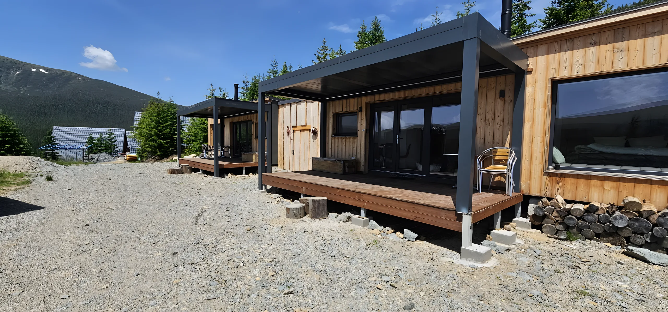 Cabane montane din lemn cu terase umbrite de copertine din aluminiu antracit