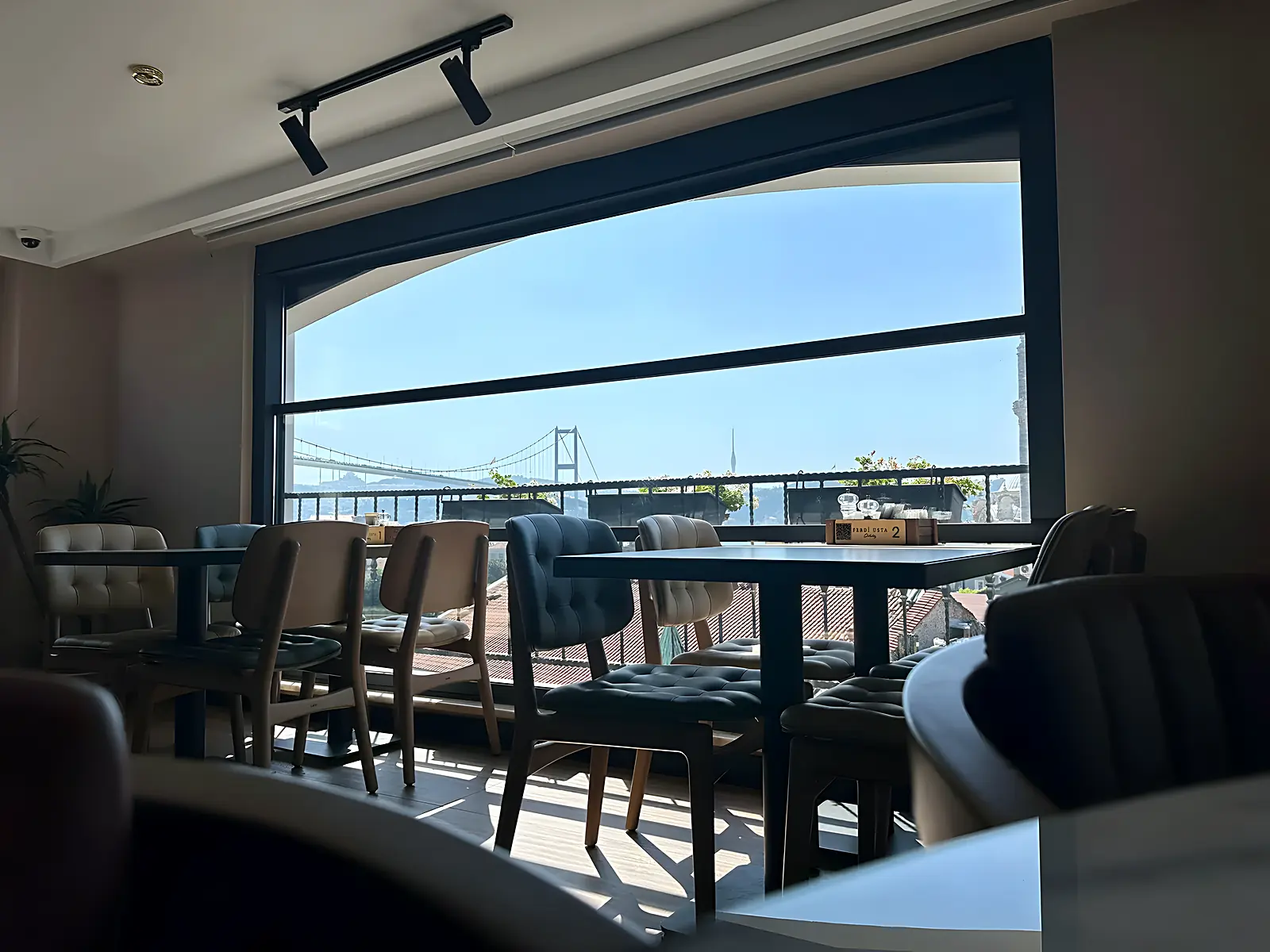 Interior de cafenea cu închidere din sticlă ghilotină, panoul superior coborât parțial