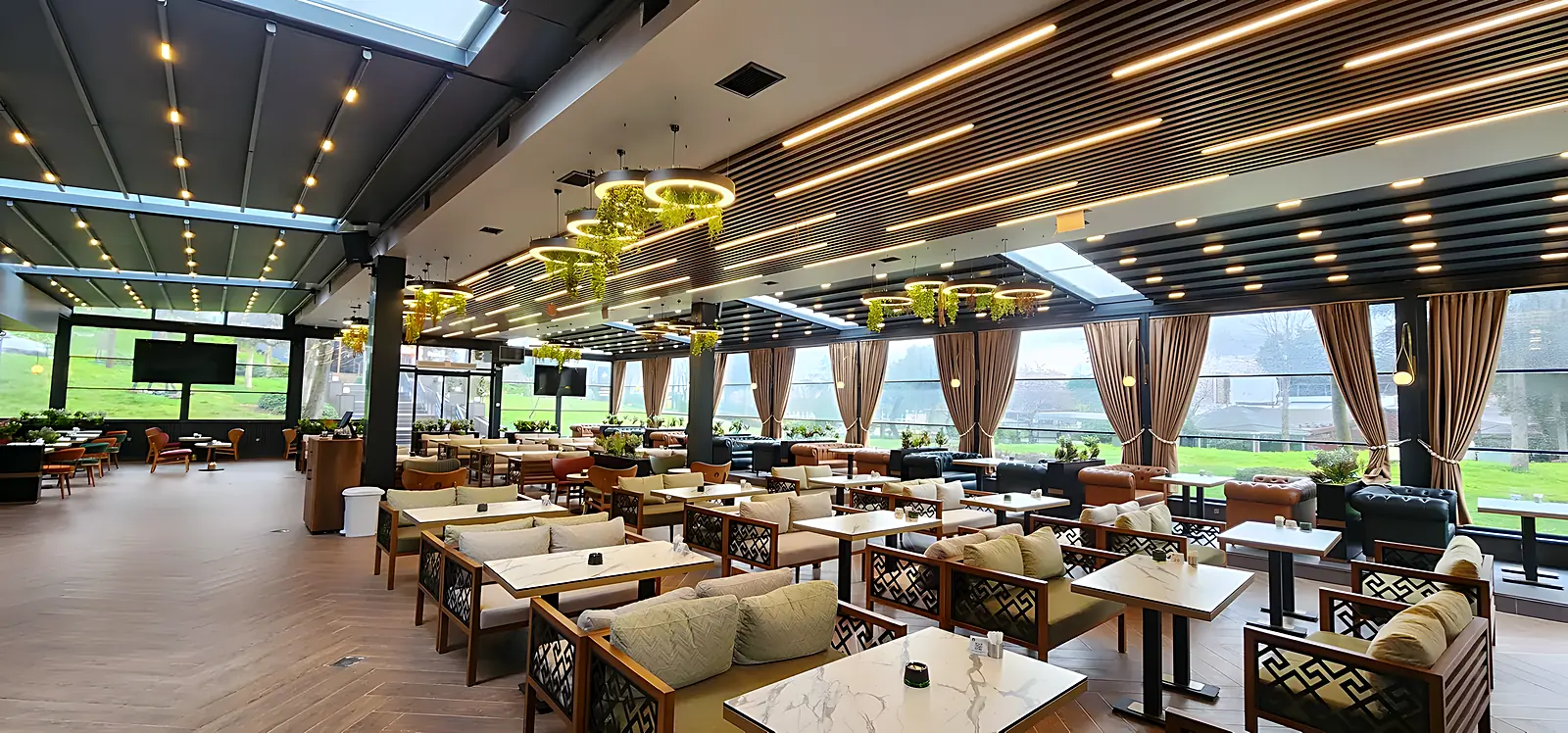 Terasă de restaurant sub pergolă cu structură de aluminiu și plafon textil, cu iluminat liniar