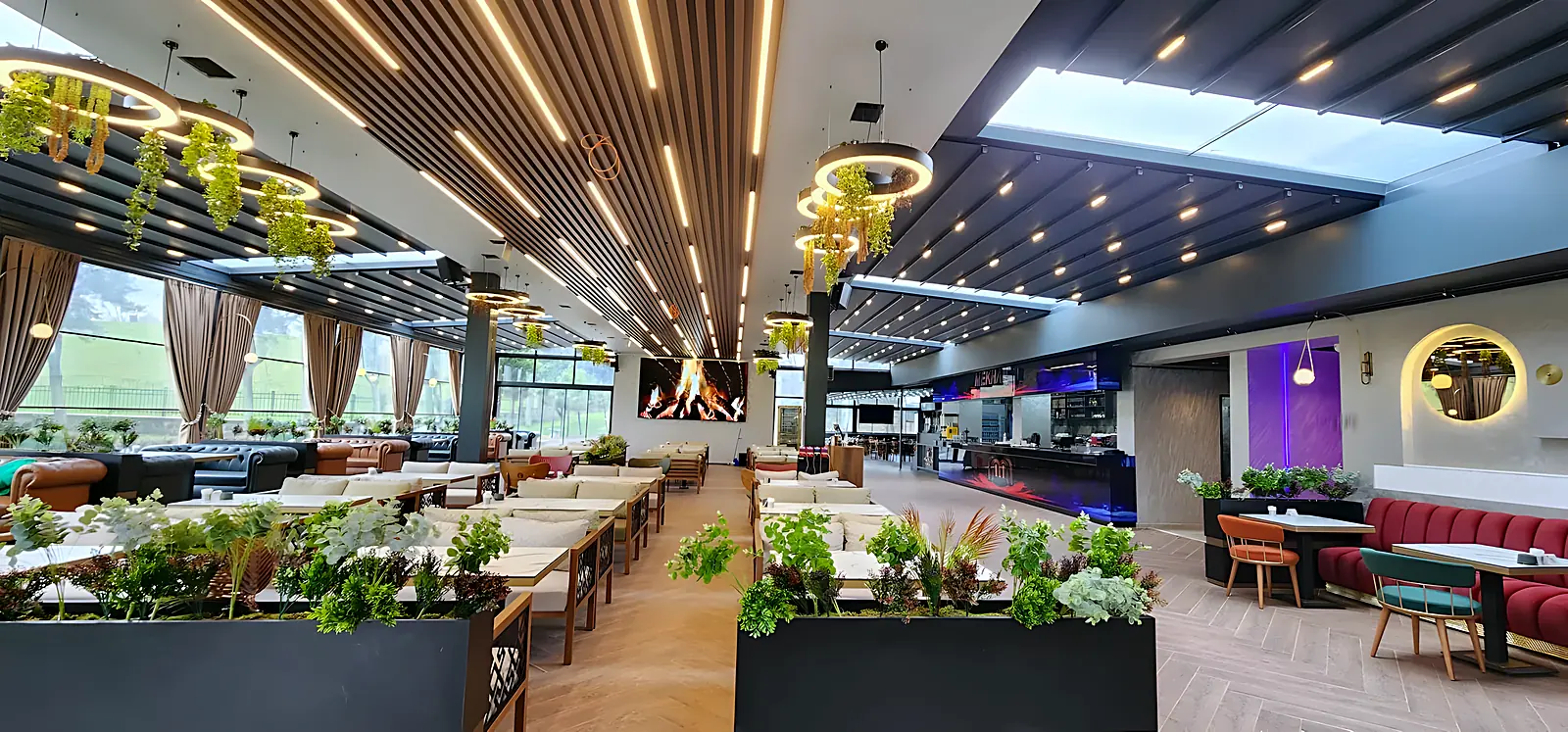 Pergolă cu acoperiș textil retractabil peste o terasă de restaurant, pânza întinsă pe șine