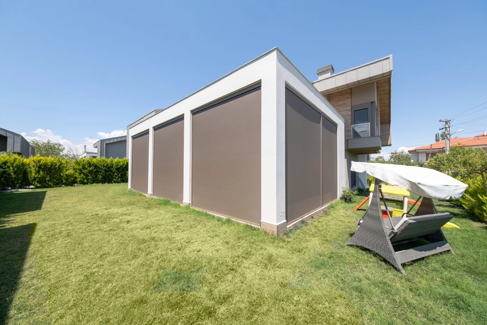 Pavilion cu screen-uri ZIP coborâte pe două laturi, văzut din grădină