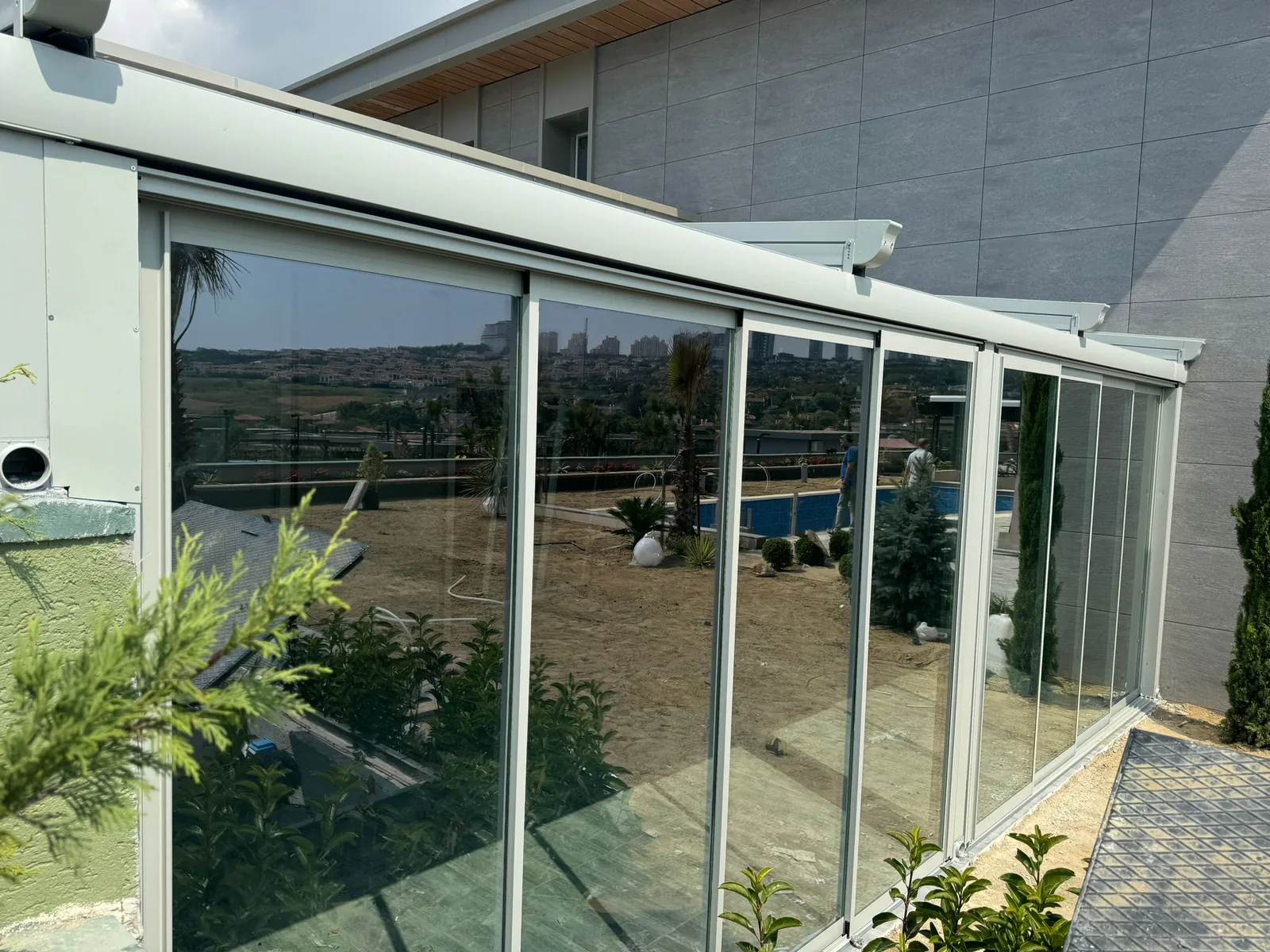 Închidere de terasă cu panouri mari de sticlă glisantă pe profile de aluminiu